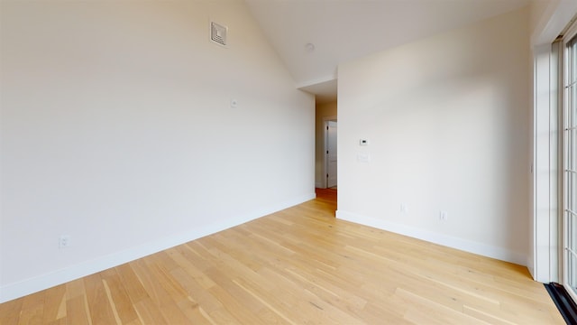 spare room featuring high vaulted ceiling and light wood-type flooring