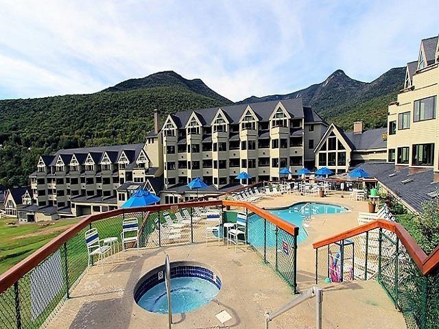 view of swimming pool with a mountain view, a patio area, and a hot tub