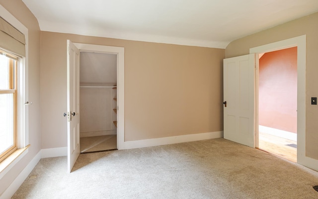 unfurnished bedroom with light carpet and a closet