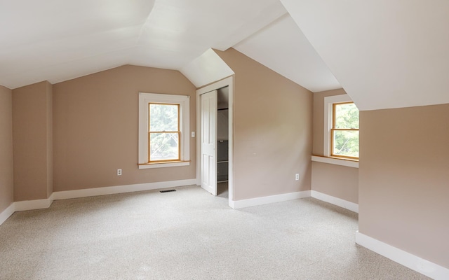 bonus room featuring light carpet and vaulted ceiling