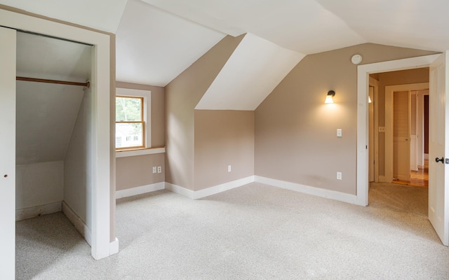 additional living space with vaulted ceiling and light carpet