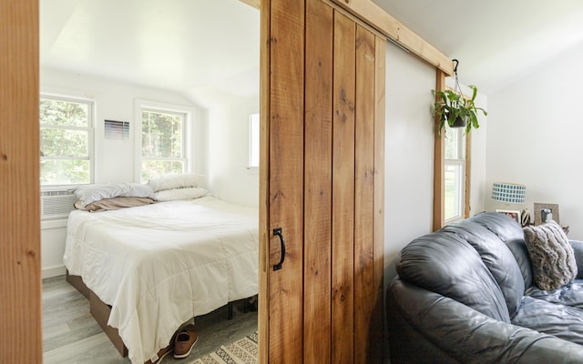 bedroom with lofted ceiling and light hardwood / wood-style floors