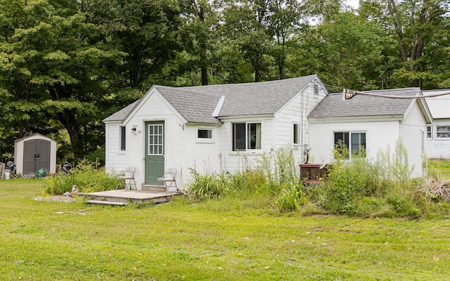 back of house featuring a storage unit and a yard