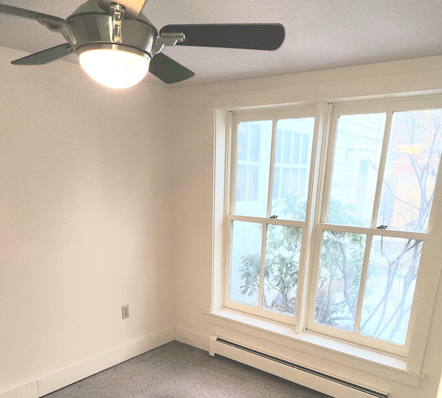 empty room featuring a textured ceiling, a healthy amount of sunlight, ceiling fan, and a baseboard radiator