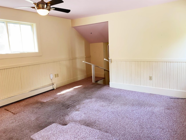 unfurnished room featuring ceiling fan, a baseboard radiator, vaulted ceiling, and carpet floors