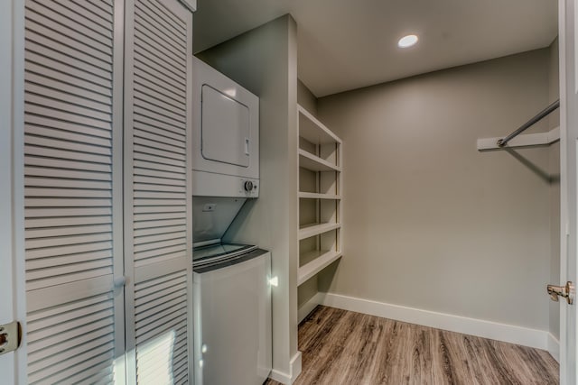 walk in closet featuring hardwood / wood-style floors and stacked washer and dryer