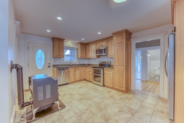 kitchen with light brown cabinetry, sink, appliances with stainless steel finishes, and light wood-type flooring