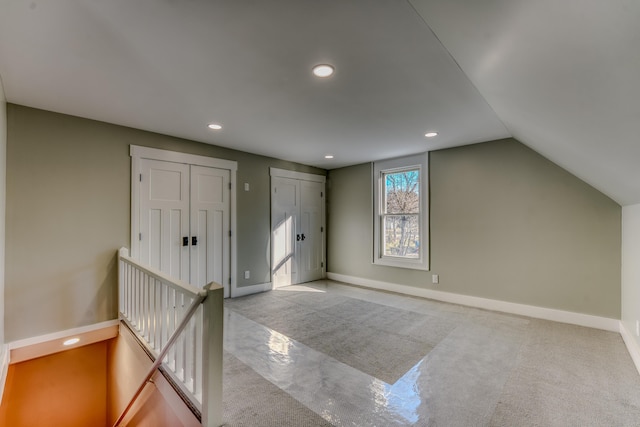 additional living space with light carpet and vaulted ceiling