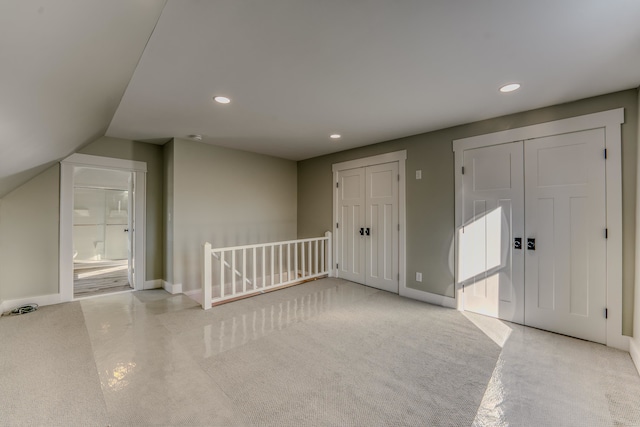 carpeted foyer entrance featuring vaulted ceiling