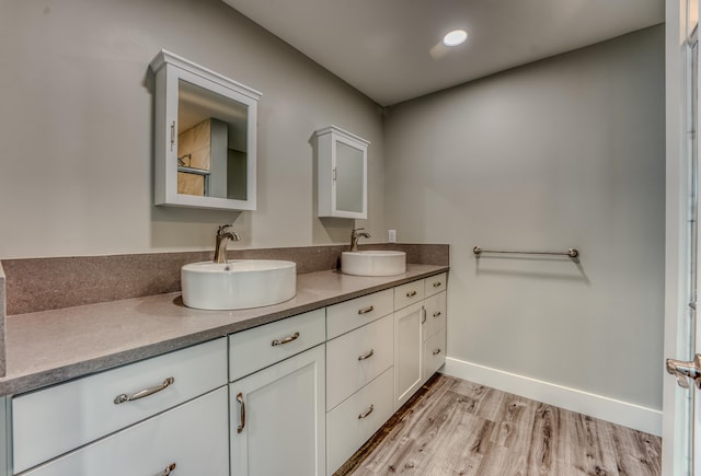 bathroom with double sink vanity and hardwood / wood-style floors