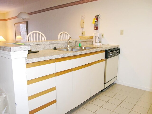 kitchen featuring sink, light tile floors, white cabinets, white dishwasher, and decorative light fixtures