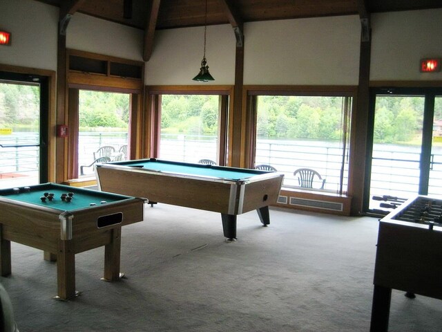 rec room with beamed ceiling, pool table, a wealth of natural light, and light colored carpet