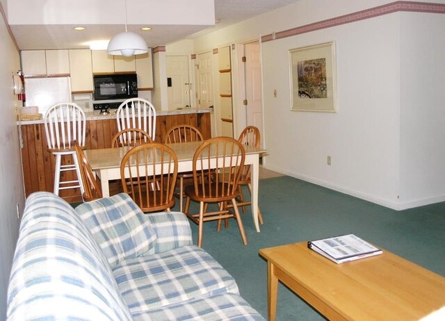 carpeted dining room with vaulted ceiling