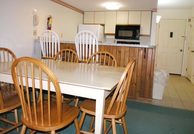 tiled dining area featuring crown molding