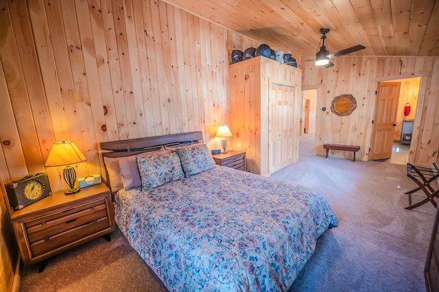 bedroom featuring wood ceiling, wooden walls, and dark carpet