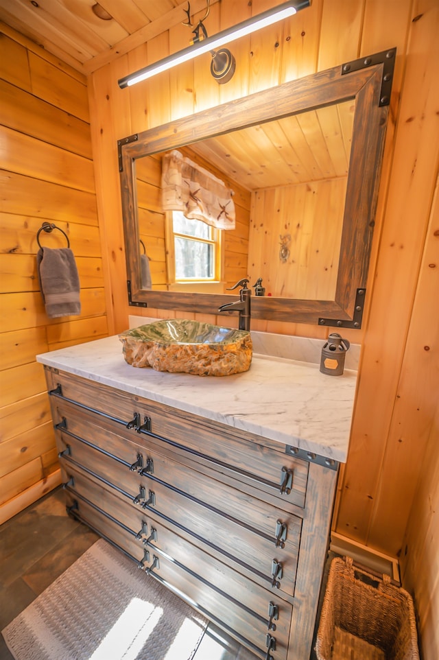 bathroom with wooden walls, large vanity, and wooden ceiling