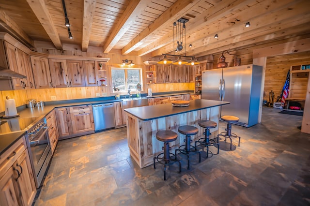 kitchen featuring a kitchen island, hanging light fixtures, a breakfast bar, beamed ceiling, and stainless steel appliances