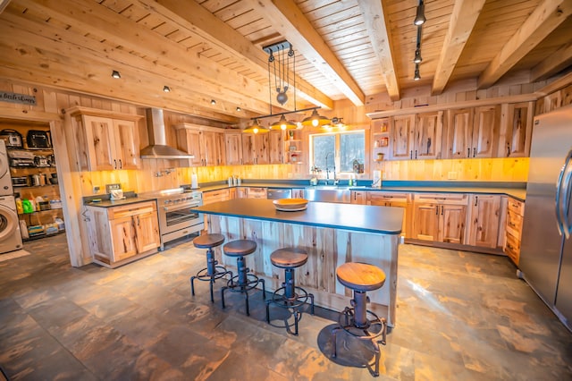 kitchen with a kitchen island, a kitchen bar, wall chimney range hood, hanging light fixtures, and beam ceiling