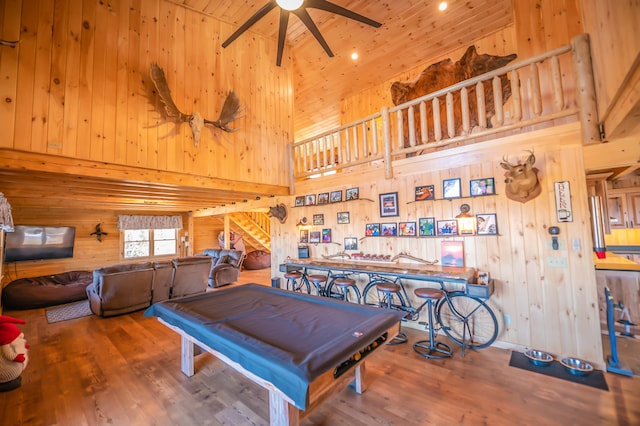 rec room with wooden walls, billiards, high vaulted ceiling, and wood-type flooring