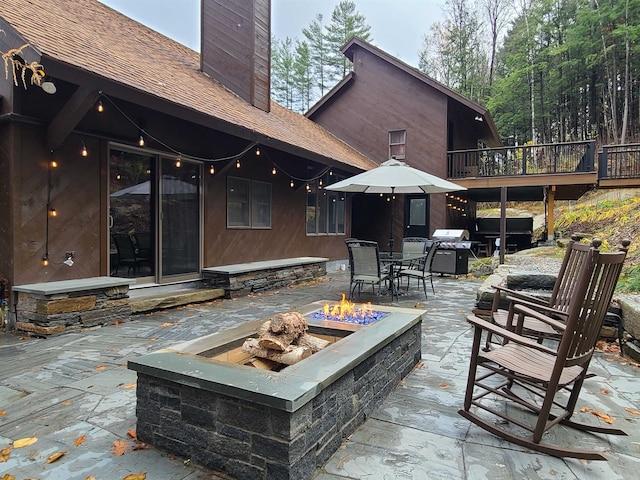 view of patio with area for grilling and a fire pit