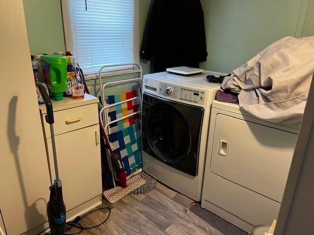 laundry area featuring cabinet space, light wood finished floors, and separate washer and dryer