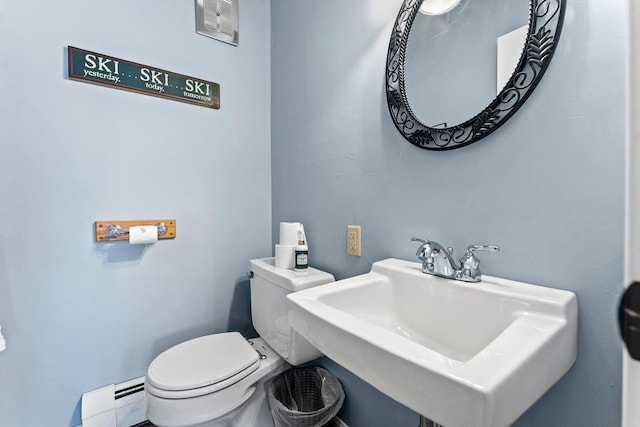 bathroom with sink, toilet, and a baseboard heating unit