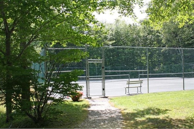 view of home's community featuring tennis court