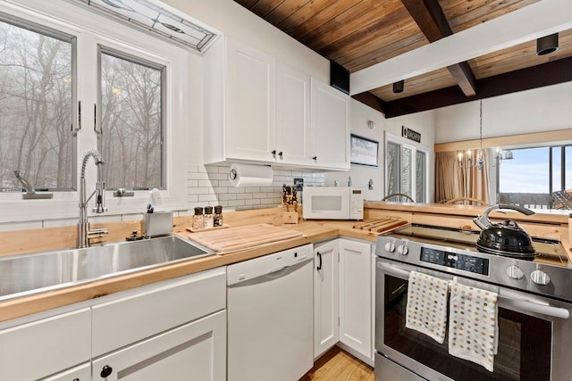 kitchen with sink, hanging light fixtures, a chandelier, white appliances, and white cabinets