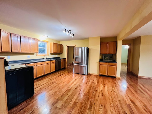 kitchen with black dishwasher, light wood-type flooring, sink, stainless steel fridge with ice dispenser, and track lighting