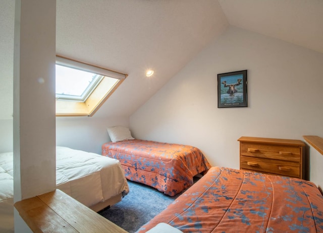 bedroom with vaulted ceiling with skylight and carpet flooring