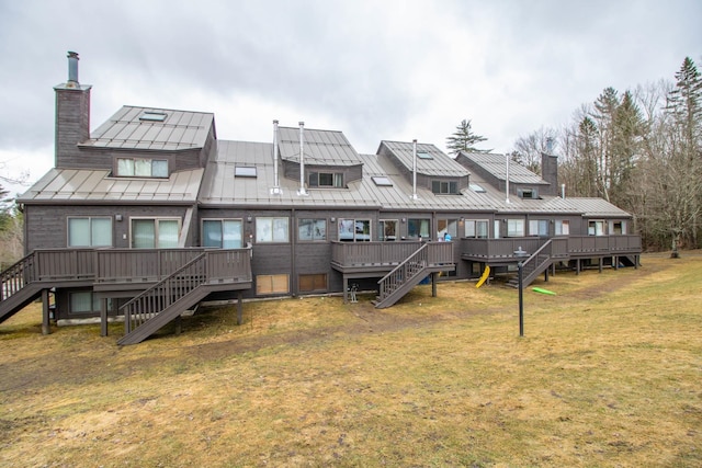 rear view of property with a deck and a lawn