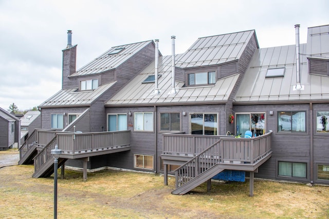 back of property featuring a lawn and a deck