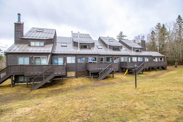 rear view of property with a yard and a wooden deck