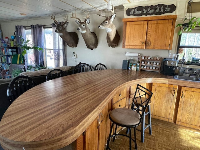 kitchen featuring brown cabinets, a sink, and a kitchen breakfast bar