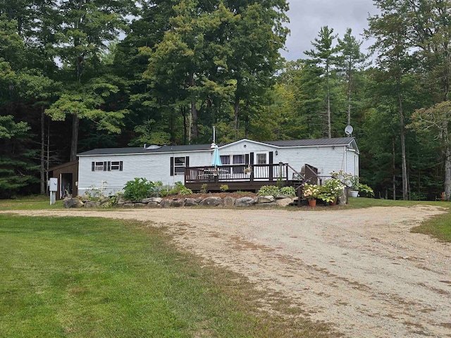 manufactured / mobile home with a front lawn and a wooden deck