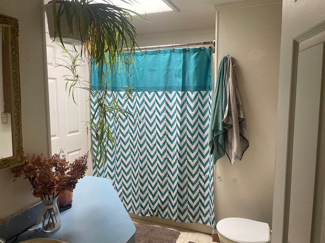 bathroom with a shower with curtain and toilet