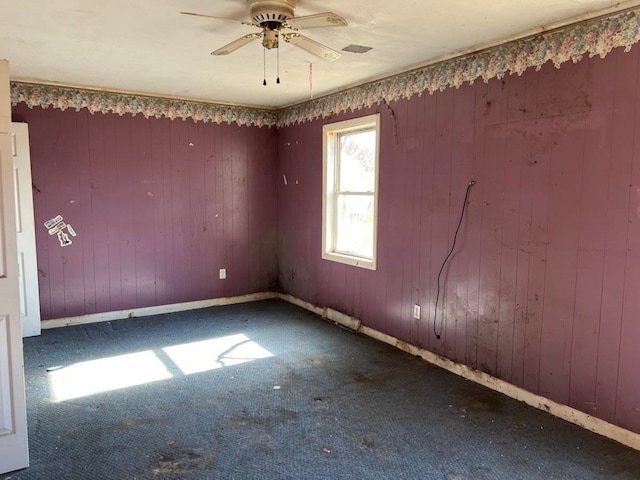 spare room featuring ceiling fan and dark colored carpet