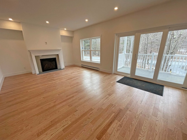 unfurnished living room featuring light hardwood / wood-style flooring and baseboard heating