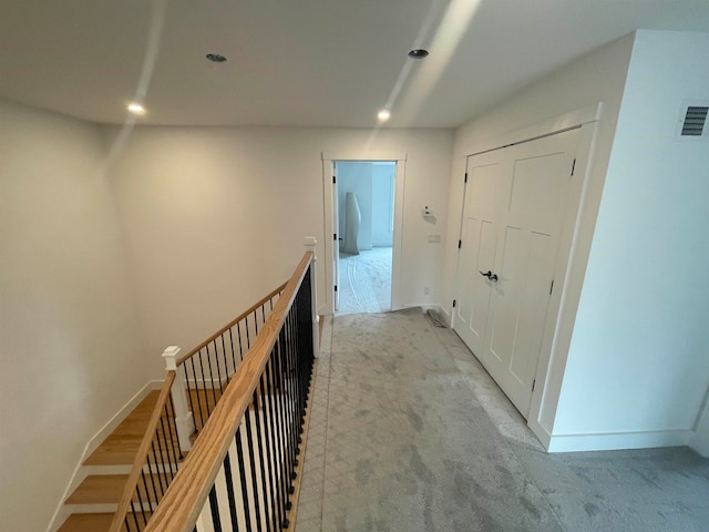 hall with light colored carpet