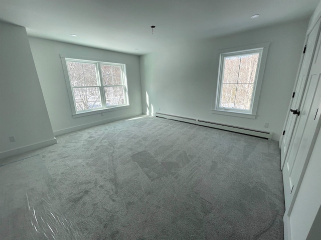 unfurnished room featuring a baseboard radiator and light colored carpet