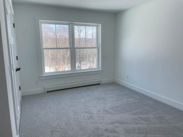 unfurnished room featuring a wealth of natural light, a baseboard radiator, and carpet