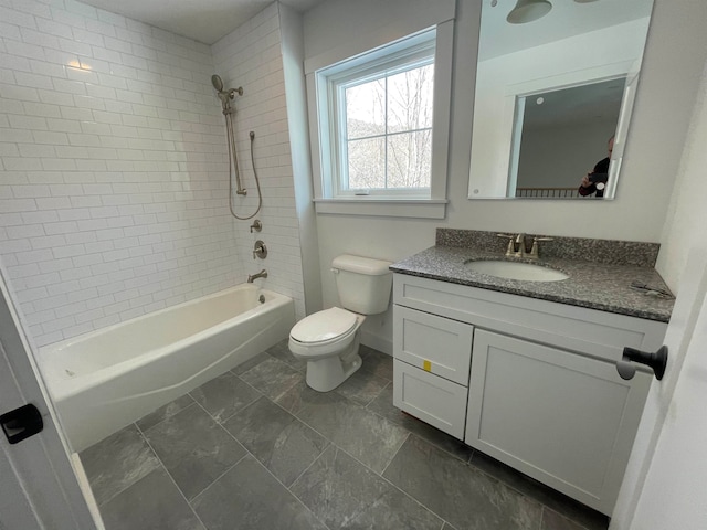 full bathroom with toilet, tiled shower / bath, vanity, and tile patterned floors