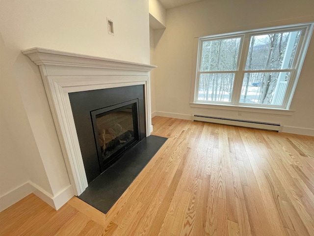 unfurnished living room featuring light hardwood / wood-style flooring and baseboard heating