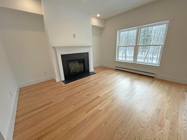 unfurnished living room with a baseboard radiator and light wood-type flooring