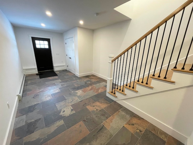 foyer entrance with dark tile patterned floors and a baseboard radiator