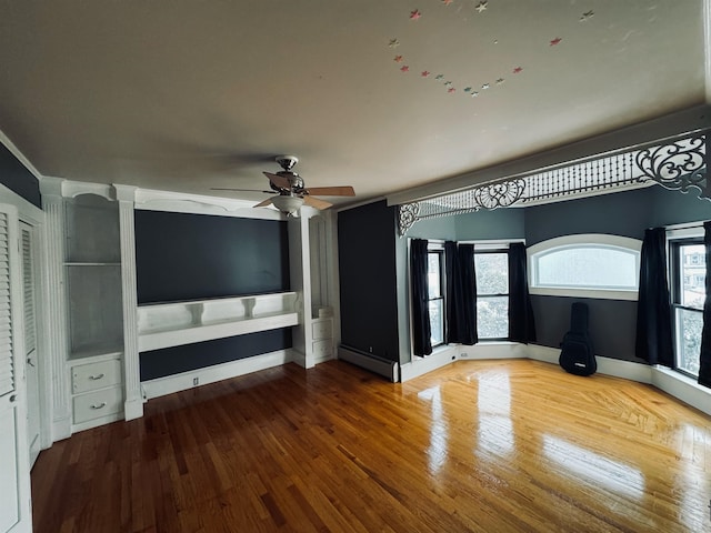 unfurnished living room with hardwood / wood-style floors, baseboard heating, and ceiling fan