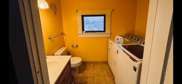 bathroom with tile floors, toilet, and washing machine and dryer