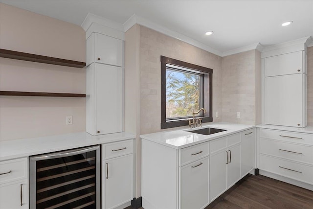 kitchen featuring light stone countertops, sink, white cabinetry, beverage cooler, and dark wood-type flooring