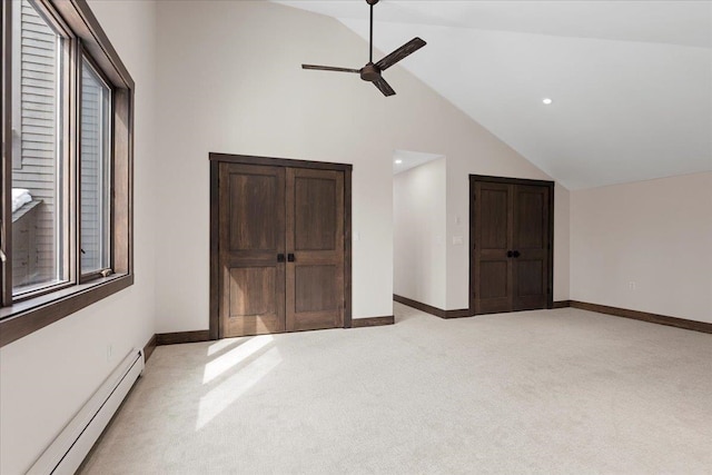 unfurnished bedroom with ceiling fan, high vaulted ceiling, baseboard heating, and light colored carpet