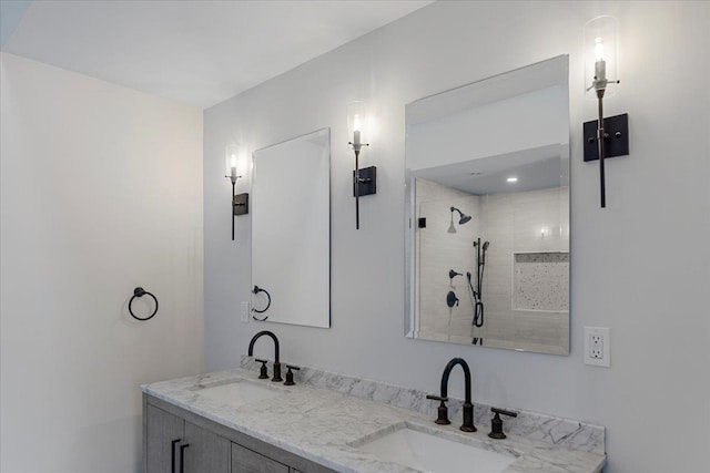 bathroom with a tile shower and vanity